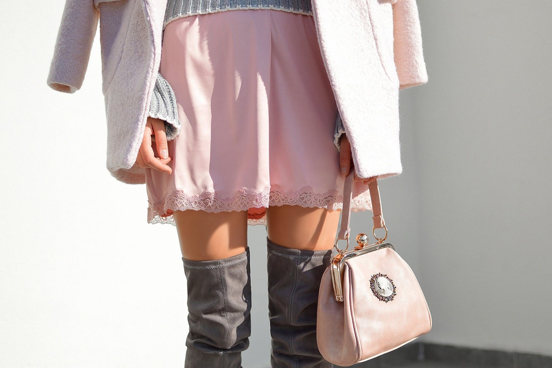 Woman wearing a pink dress and grey boots