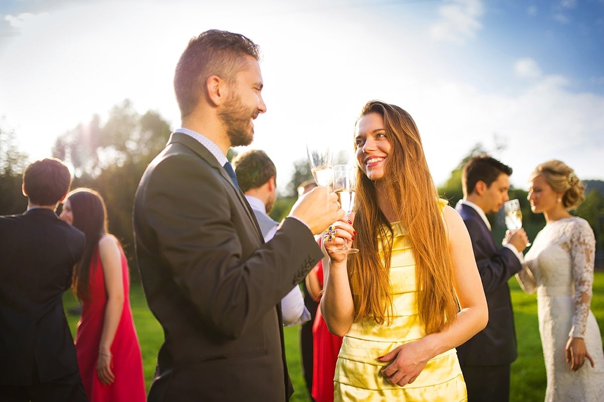 Man and woman drinking champagne at a wedding