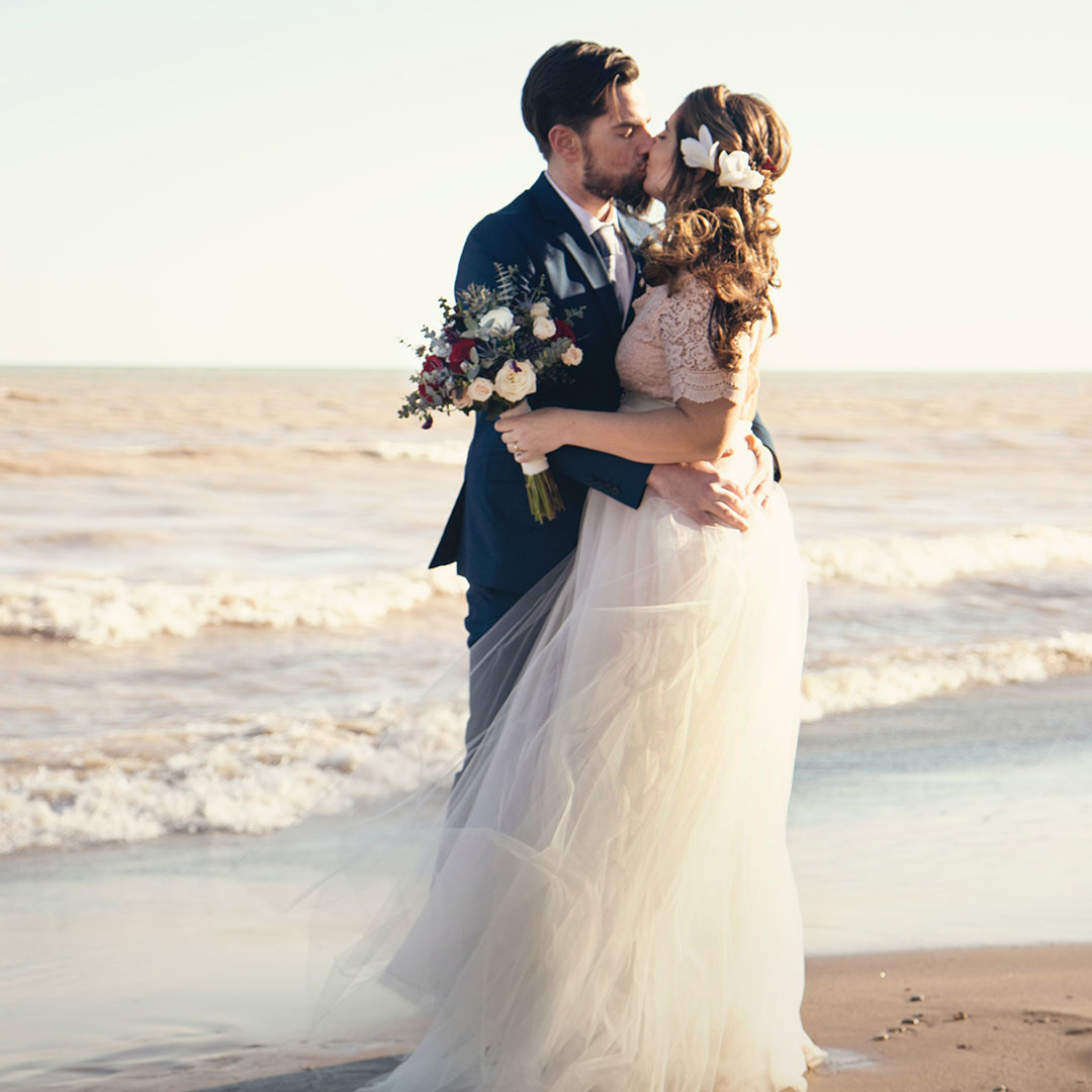 Newlyweds kissing on the beach