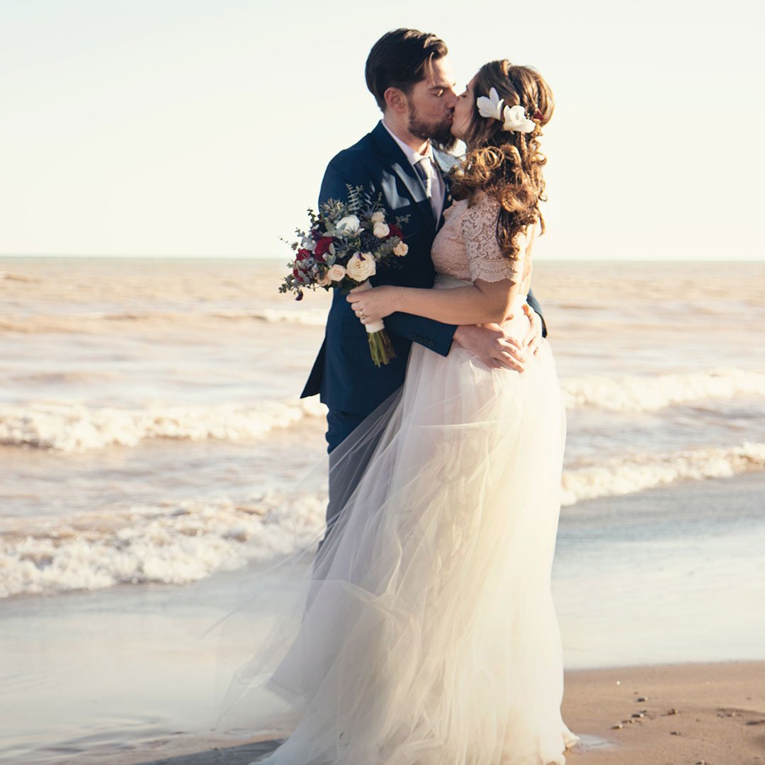 Newlyweds kissing on the beach