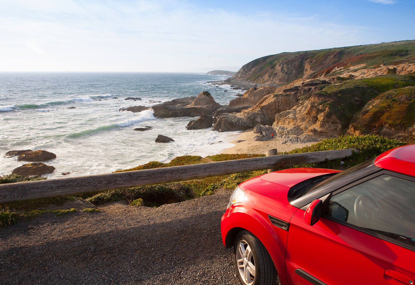 Red car in front of a sea landscape