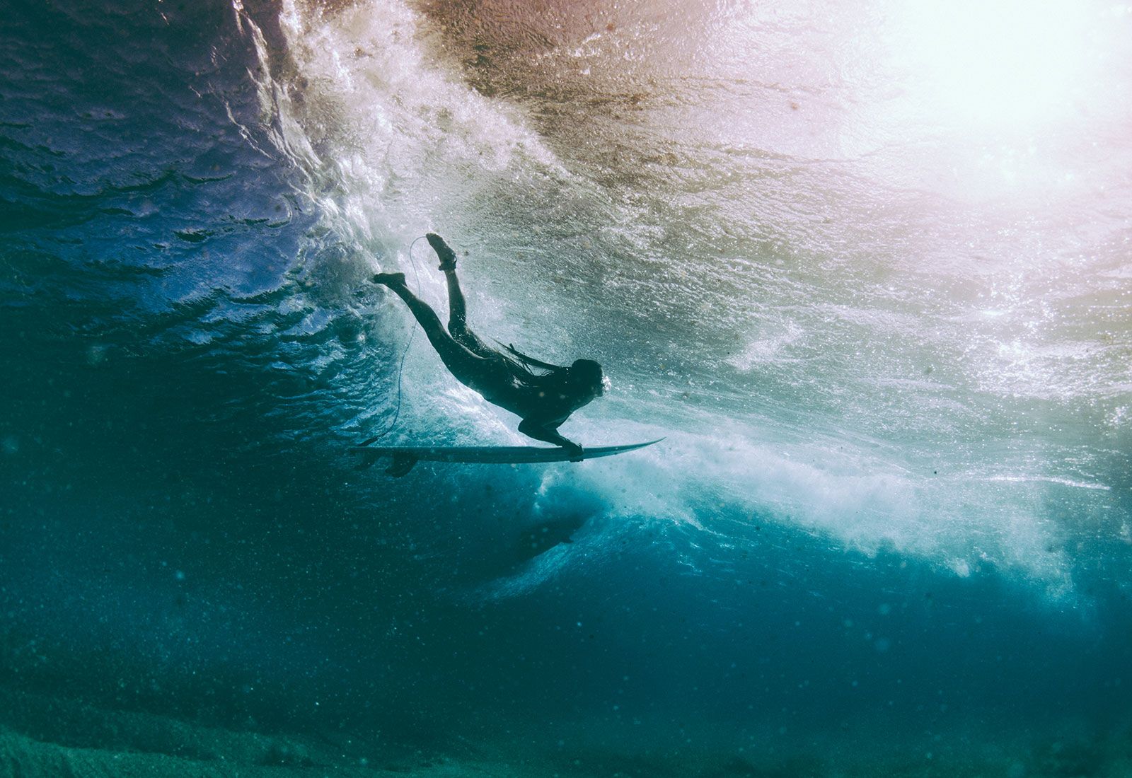 Surfer duck diving under a wave