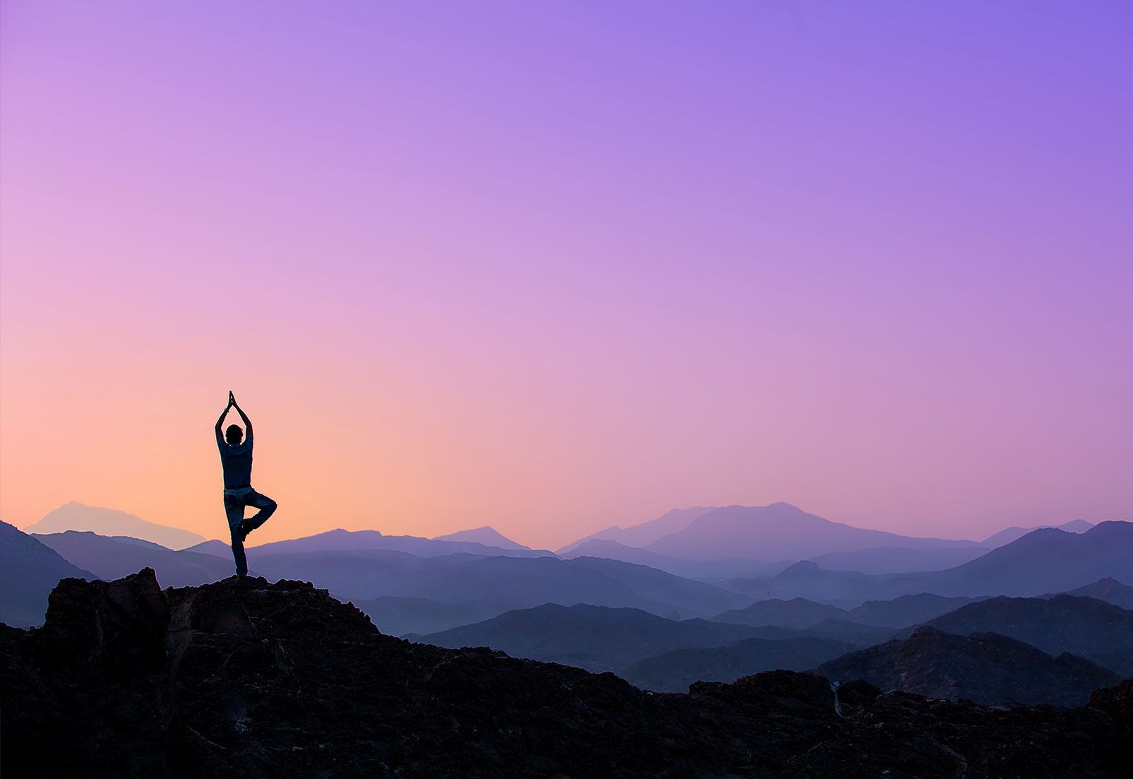 Person doing yoga on a mountain hill