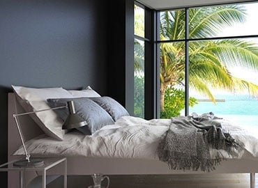 Bedroom with grey walls, large double bed and a sea view