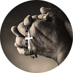 Person holding a silver cross necklace