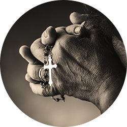 Person holding a silver cross pendant