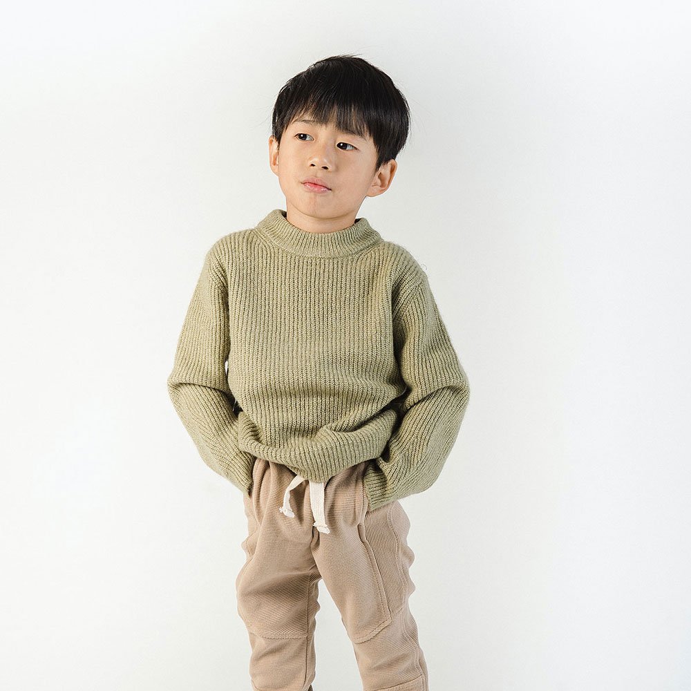 Young boy wearing knitted jumper